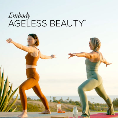 Two white women in workout gear, outdoors on yoga mats, holding a warrior two yoga pose with text that says Embody Ageless Beauty.