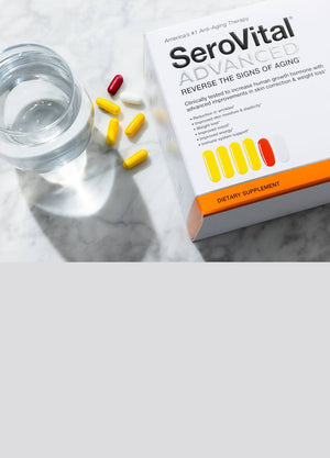 A box of SeroVital ADVANCED, which reverses the signs of aging, on a white marble countertop next to a glass of water with 4 yellow capsules, 1 red capsule and 1 white capsule