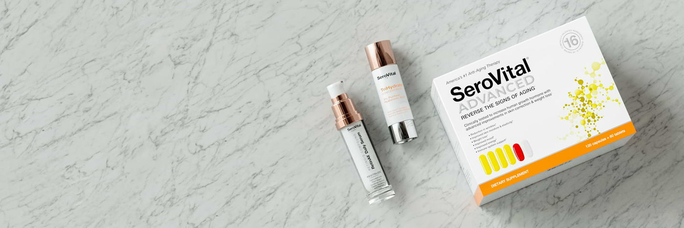 A tube of hyaluronic acid serum TriHydrate, retinoid serum RetinAll, and beauty boosting SeroVital ADVANCED lying on a marbled background